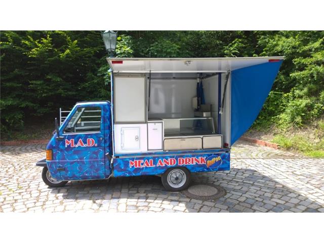 Piaggio Ape Dreirad vor dem Umbau - blaues M.A.D. Meal and Drink Fahrzeug mit einfacher Ausstattung